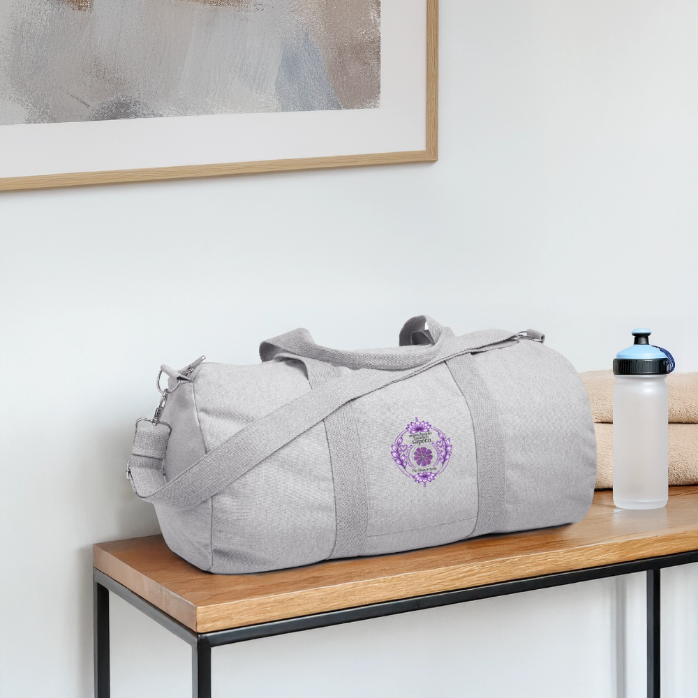 Graue Sporttasche von ungeschminkt natuerlich sapeco mit violettem Kronenchakra-Motiv auf einer Bank – praktische Tasche für Yoga, Fitness und Reisen.