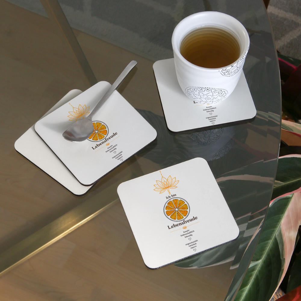 Untersetzer „Ich bin Lebensfreude“ mit orangefarbenem Sakralchakra-Motiv in Anwendung mit Tasse und Löffel